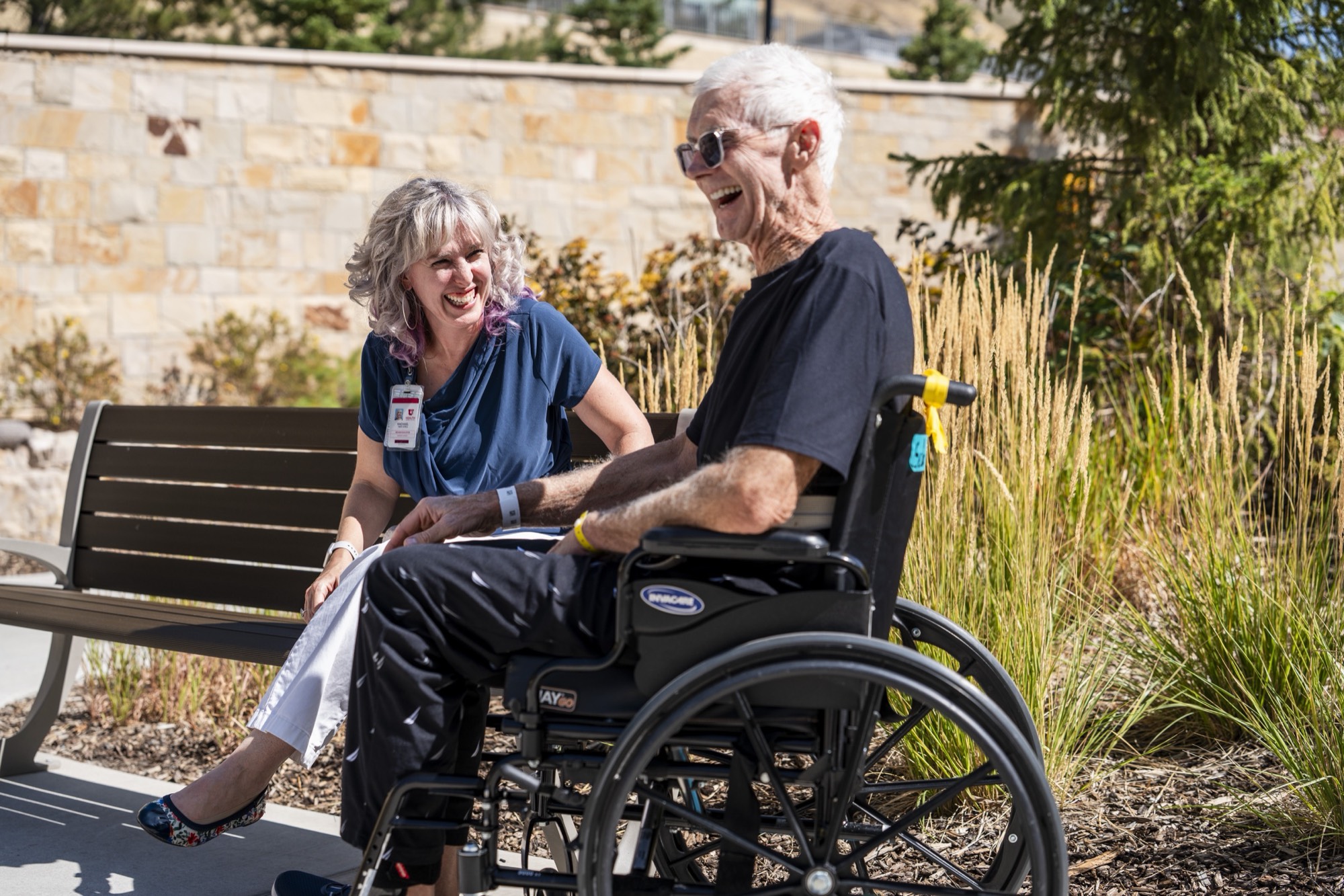 People in wheelchairs outdoors in a garden